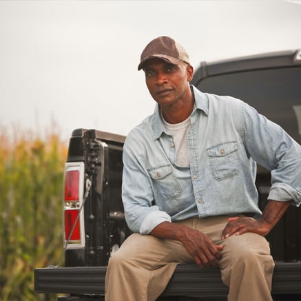 farmer sitting in the back of truck