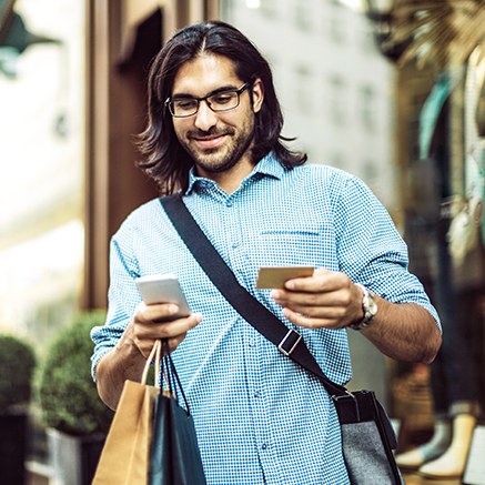 man walking with shopping bags on mobile phone