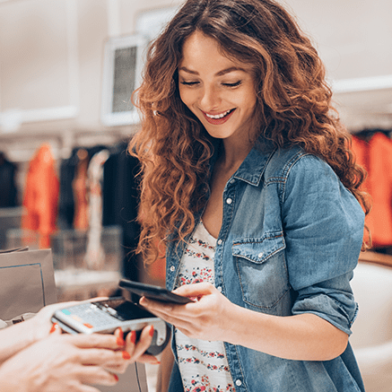 woman paying at counter with mobile phone